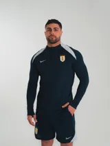 Remera de entrenamiento Nike color azul marino con detalles en gris en los hombros y logo de la selección uruguaya en el pecho.