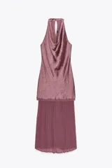 Vestido midi color lila, de cuello halter y sin mangas. La parte superior es de tejido arrugado y la falda es plisada. Tiene abertura en la espalda con cierre de botones ocultos.