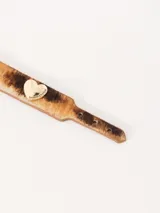 Pulsera marrón de cuero con hebilla dorada y dijes de corazón.