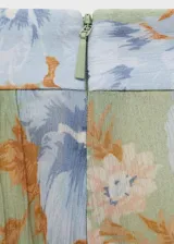 Pantalón largo de gasa con estampado floral en tonos verde, celeste y marrón. Diseño balloon con detalle de lazos en el bajo y tiro medio.