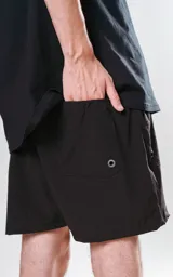 Short de baño negro de calce regular con cuatro bolsillos, elástico en la cintura y cordón para ajustar.