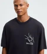 Remera de algodón color negro, corte regular, cuello redondo y manga corta. Presenta un estampado localizado con lettering "Burn Inside" al frente y un diseño gráfico denominado "Dystopia" en la espalda.