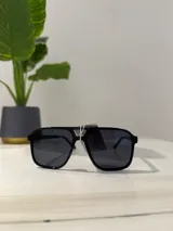 Lentes de sol negros con forma aviador.