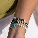Set de tres pulseras elásticas de mostacillas de colores con diseño floral.