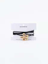 Gargantilla choker con cordón fino de terciopelo negro y dije de flor dorada.