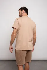 Remera color beige con estampado de estilo Art Decó en el frente.