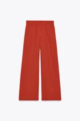 Pantalón marrón de tiro alto con cintura elástica, bolsillos delanteros y pernera ancha.