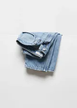 Pantalón de jean celeste de corte mom fit, tiro alto, cinco bolsillos y cierre con cremallera y botón.