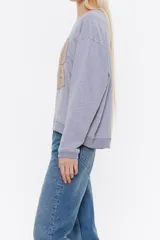 Sudadera corta negra de algodón con cuello redondo y mangas largas. Estampado frontal con el logo de la marca Bimba y Lola en color dorado.