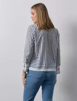 Blusa de gasa estampada a rayas verticales blancas y negras, marca Sioni. Espalda con abertura y botón. Manga larga con puño y botón.