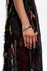 Pulsera rígida plateada de metal con textura irregular y cierre de bisagra.