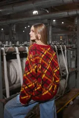 Sweater de lana tejido y bordado a mano en Uruguay, de calce holgado con cuello a la base y puños. Diseño con rombos en tonos rojo, negro, amarillo y marrón.