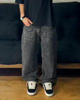 Pantalón jean gris oscuro con efecto lavado y corte mega baggy. Presenta detalles desflecados en la parte trasera de las piernas.