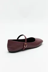 Balerinas color borgoña de cuero sintético texturizado, con tira sobre el empeine y hebilla metálica ajustable.