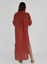 Vestido camisero largo color beige, con cuello clásico, abotonadura frontal completa, mangas 3/4 con trabilla y aberturas laterales.