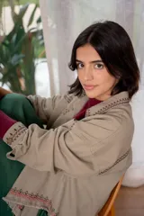 Campera de jean color beige con bordados florales en tonos rosa, verde y amarillo.