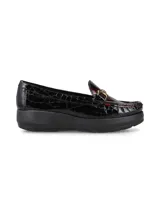 Mocasín de cuero charol negro con plataforma blanca y detalle de hebilla metálica plateada en el empeine.
