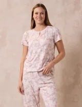Conjunto de pijama marca René Rofé, compuesto por remera de manga corta con escote redondo y botón, y pantalón capri con cintura elastizada.
