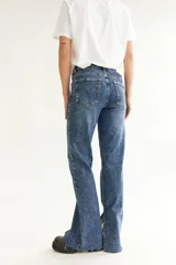 Pantalón de jean azul con efecto lavado, corte recto y tajo en la pierna.