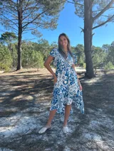 Vestido midi de seda con estampado floral en tonos azul y blanco, escote en V y mangas cortas.
