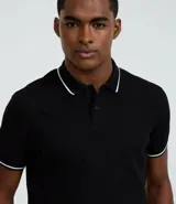 Remera polo blanca de media malla texturizada a rayas, corte regular, con cuello y mangas cortas en ribana con detalle contrastante en negro.