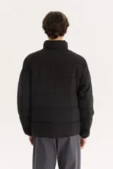 Campera puffer negra con cuello alto y cierre frontal con cremallera.