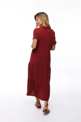 Vestido midi color borgoña, con cuello camisero, manga corta y falda escalonada.