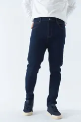 Pantalón de jean gris oscuro, corte carrot, tiro medio, con logo bordado y presillas para cinturón.