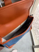 Cartera bandolera de jeans con detalles en cuero color marrón.