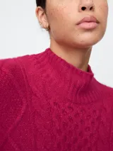 Sweater de punto trenzado color celeste con cuello alto.