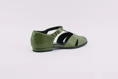 Zapatos bajos rojos de cuero, con puntera redondeada y tira central con hebilla. Presentan aberturas laterales.