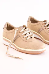 Zapatillas deportivas acordonadas color beige con suela de plataforma blanca y detalles en color plata.