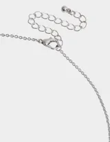 Cadena corta dorada con dije de corazón entrelazado con el símbolo de infinito, ambos adornados con strass.