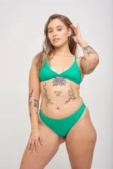 Bikini de lycra azul con corpiño triangular de breteles finos y tanga cavada con laterales fruncidos.