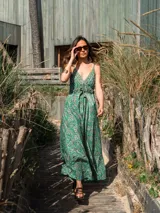 Vestido largo de seda con estampado floral en blanco y negro, breteles finos ajustables, escote en V y corte a la cintura con lazo.