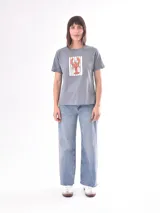 Remera color crudo con estampado de un pez rojo en el frente.