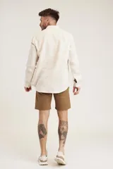 Camisa de lino color crudo, de manga larga y corte clásico.