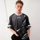 Camiseta de fútbol adidas Originals Adilenium Season 3 Team Jersey, color negro con detalles en gris y blanco. Presenta cuello en V, logo de adidas bordado en el pecho y diseño geométrico en la parte inferior.