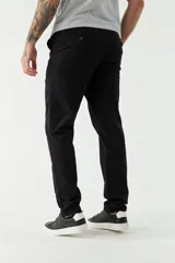 Pantalón chino color beige, de corte slim, con bolsillos laterales y traseros. Se ajusta a la cintura con cinturón de cuero marrón.