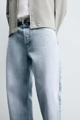 Pantalón de jean celeste de corte recto, con cinco bolsillos, efecto lavado y cierre frontal con botones.