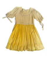 Vestido a la rodilla color amarillo, con bordado floral en el pecho, mangas 3/4 abullonadas con lazos y falda fruncida.