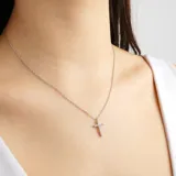 Collar plateado con dije de cruz con incrustaciones de strass.