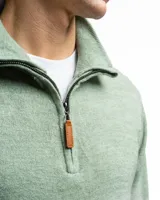 Sweater verde de punto con cuello alto y cierre medio con cremallera.