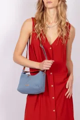 Cartera rectangular armada de tela denim azul y ecocuero marrón.