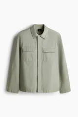 Sobrecamisa verde oliva de corte recto, con cuello inglés, cierre frontal con botones a presión y dos bolsillos de parche con solapa en el pecho.