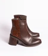 Bota corta de cuero marrón con detalle de cuero con textura de cocodrilo en el lateral y en el taco. Tiene cierre del lado interno y taco de madera forrada en cuero de 7cm.