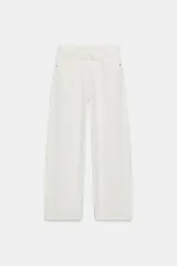 Pantalón de jean blanco de tiro bajo con cinco bolsillos y corte amplio. Detalle de cintura doblada. Cierre frontal con cremallera y botón metálico.
