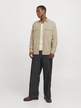 Sobrecamisa beige de manga larga con cuello clásico y fit cómodo. Confeccionada en tejido de sarga resistente de algodón y lino, con cierre con botones y bolsillos en el pecho con cierre de botón.