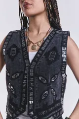Chaleco negro de jean con bordados y apliques plateados.