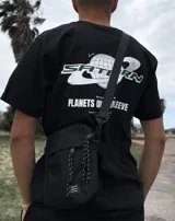 Bandolera negra con correa ajustable y cinco bolsillos.